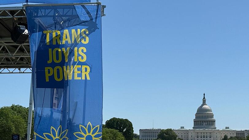 „Trans joy is power“ steht auf einem Banner an einer Bühne vor dem Kapitol am ersten Tag der Worldpride.