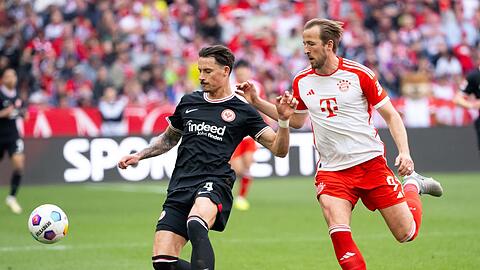 Harry Kane (r) von München und Robin Koch von Frankfurt kämpfen um den Ball.