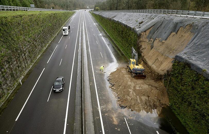 Autobahn mal anders. In Spanien reparieren Bauarbeiter ein Teilstück der Straße, das nach einem Erdrutsch nicht mehr befahrbar war.