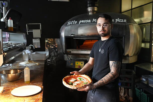 Pizzabäcker Adriano schiebt jede Pizza für eine Minute bei 485 Grad in den Ofen. Pizzabäcker Adriano schiebt jede Pizza für eine Minute bei 485 Grad in den Ofen.