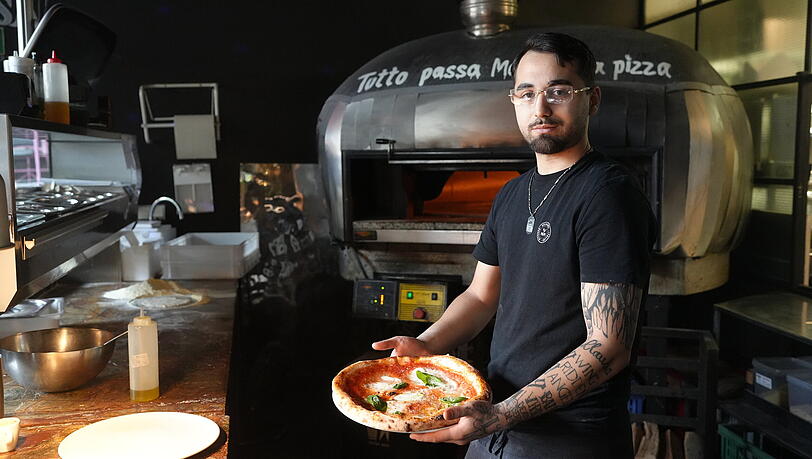 Pizzabäcker Adriano schiebt jede Pizza für eine Minute bei 485 Grad in den Ofen. Pizzabäcker Adriano schiebt jede Pizza für eine Minute bei 485 Grad in den Ofen.