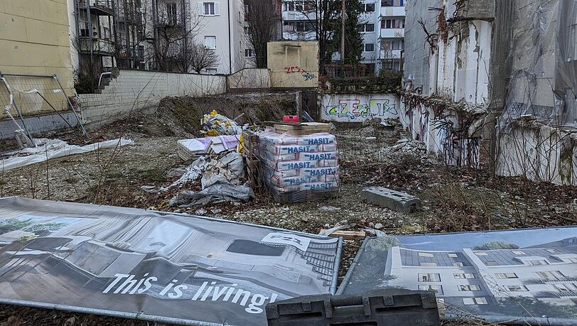 Falkenstraße 21: "This is living" verspricht das Werbe-Transparent auf dem Bauzaun, der mittlerweile wieder aufgerichtet wurde. Der Bezirksausschuss betitelte das Grundstück, das seit Jahren brach liegt, zuletzt eher als "Schandfleck".