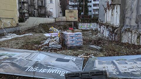 Falkenstraße 21: "This is living" verspricht das Werbe-Transparent auf dem Bauzaun, der mittlerweile wieder aufgerichtet wurde. Der Bezirksausschuss betitelte das Grundstück, das seit Jahren brach liegt, zuletzt eher als "Schandfleck".