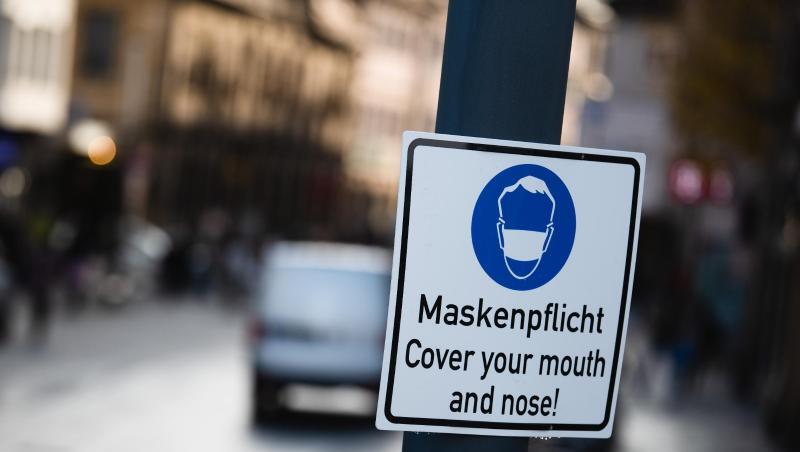 Ein Schild weist auf das Tragen einer Maske hin.