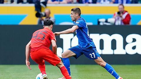 Münchens Aleksandar Pavlovic (l) und Hoffenheims Andrej Kramaric kämpfen um den Ball.