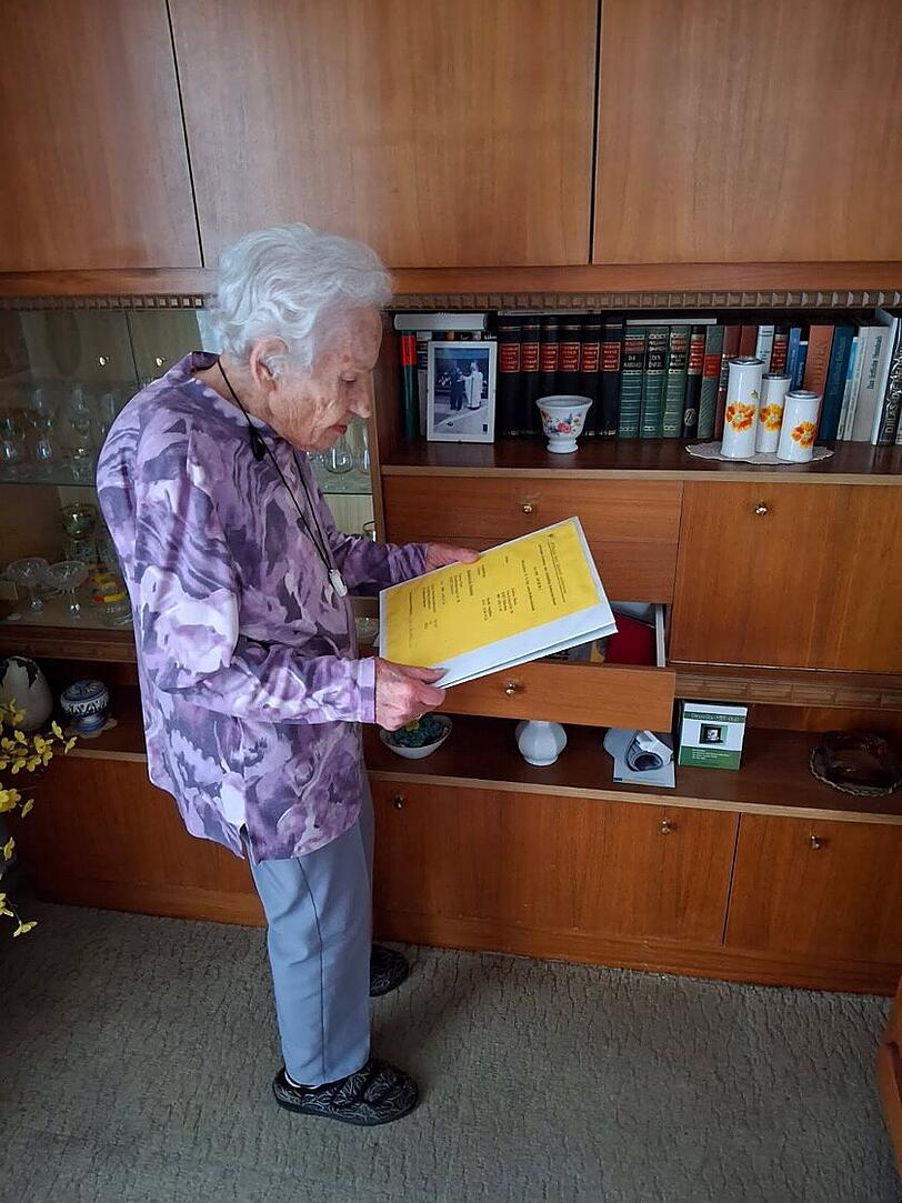 Maria Endres vor dem Wohnzimmerschrank, in dem sie ihre Dokumente aufbewahrt.