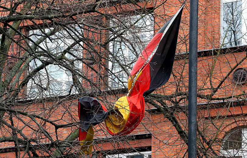 Eine Deutschlandfahne hat sich am 30.03.2015 bei Sturmböen vor einer Schule in Berlin in einem Baum verheddert. Nach Angaben der Meteorologen wird in den kommenden Tagen weiter mit Regenschauern und heftigen Windböen, bei Temperaturen im einstelligen Bereich, zu rechnen sein.