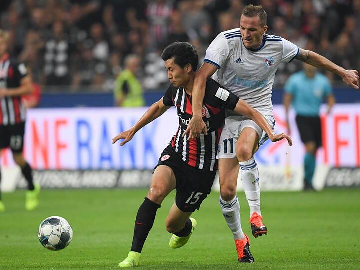 Frankfurts Daichi Kamada (l) setzt sich gegen den Dimitri Lienard von Racing Straßburg beim Kampf um den Ball durch.
