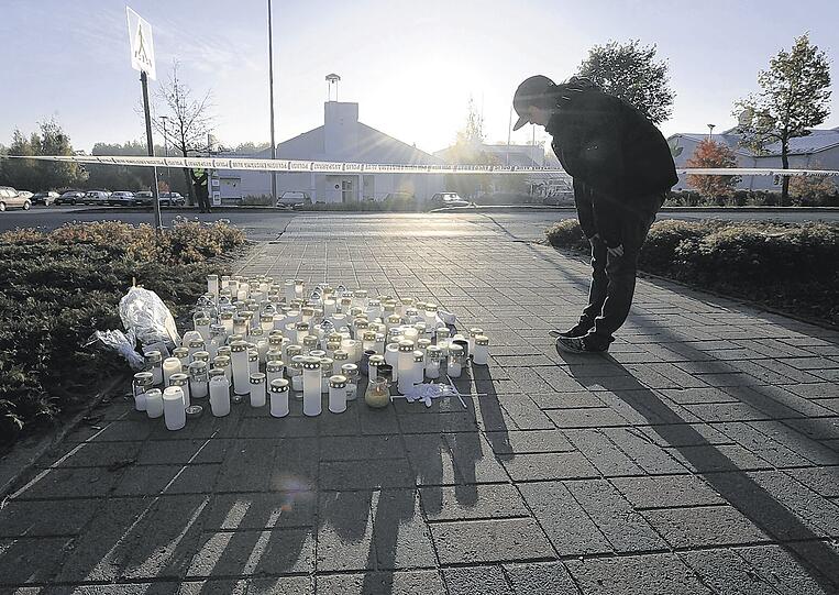 Eine Verbeugung vor den Toten: Ein Mitschüler gedenkt vor einer Ansammlung von Kerzen den Opfern des finnischen Amokläufers.Fotos: AFP