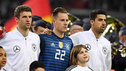 Singt kräftig mit: Thomas Müller (li.) vom FC Bayern bei der Nationalhymne.