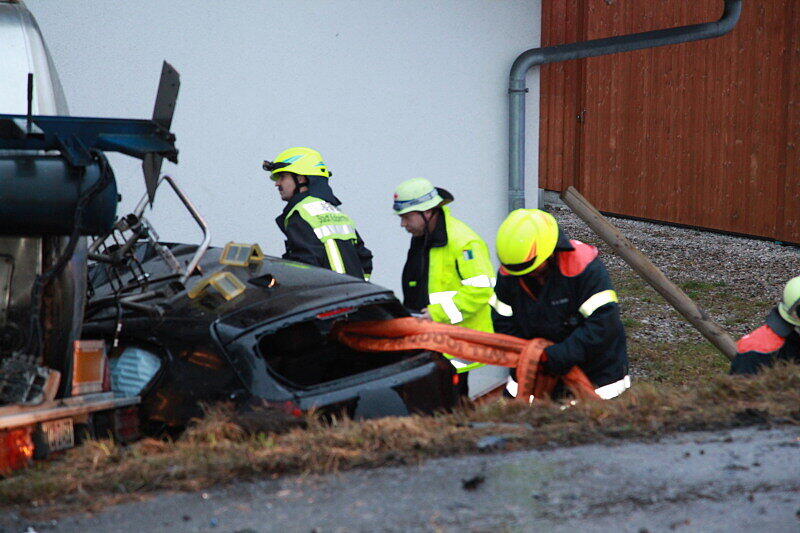 Ein mit 25 Tonnen Rahm beladener Lkw stößt am Sonntagmorgen mit einem BMW zusammen, stürzt in einen Graben und begräbt das Auto halb unter sich.