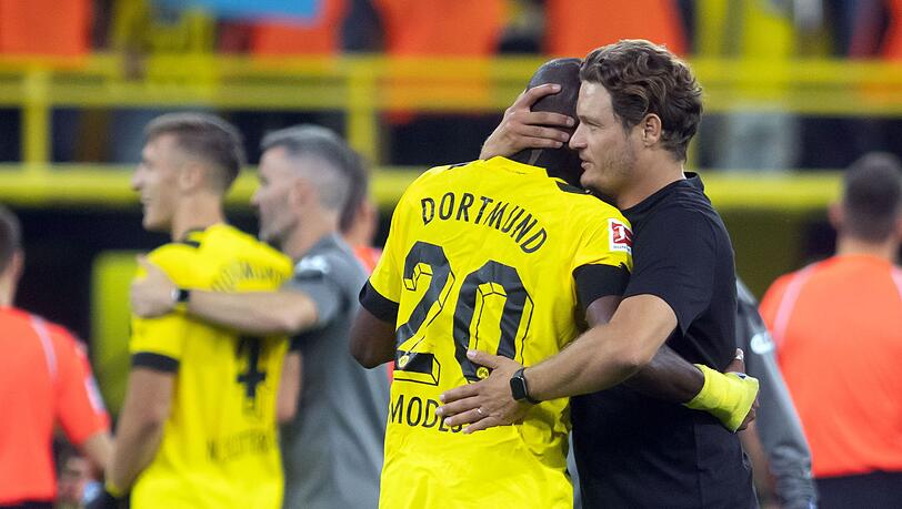 Dortmunds Trainer Edin Terzic (r) umarmt Anthony Modeste.
