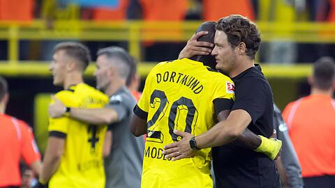 Dortmunds Trainer Edin Terzic (r) umarmt Anthony Modeste.
