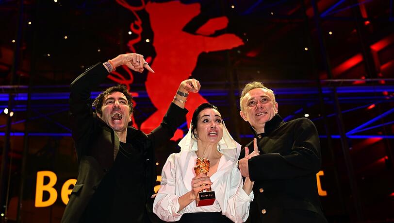 Ilker &Ccedil;atak (l-r), Regisseur des Films "Gelbe Briefe" und seine Darsteller &Ouml;zg&uuml; Namal und Tansu Bicer mit dem Goldenen B&auml;ren.