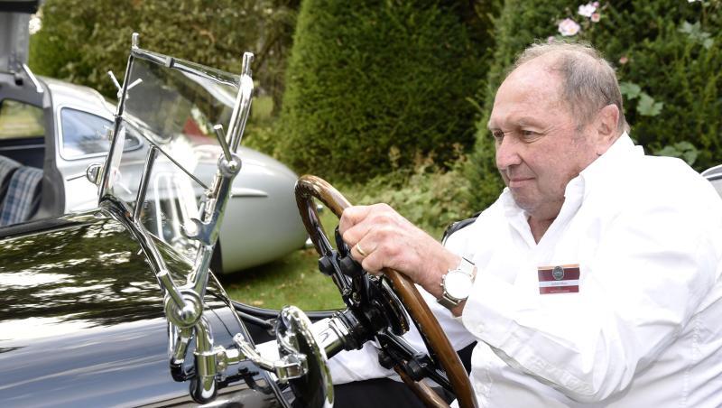 Jochen Mass sitzt hinter einem Steuer.