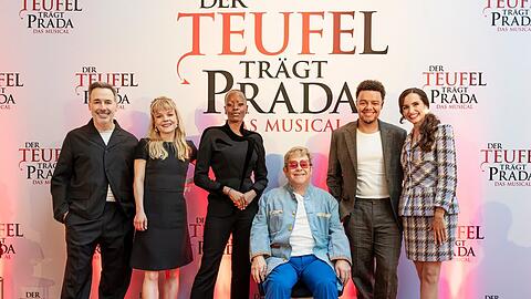Elton John (Mitte) und Ehemann David Furnish (l.) mit dem deutschen Cast von "Der Teufel tr&auml;gt Prada - Das Musical": Isabel Waltsgott, Florence Kasumba, Elindo Avastia und Alexandra-Yoana Alexandrova (v.l.n.r.)