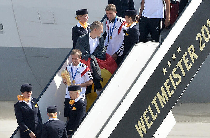 Da sind sie: Angeführt von Kapitän Philipp Lahm betreten die deutschen Spieler nach acht Wochen wieder deutschen Boden.