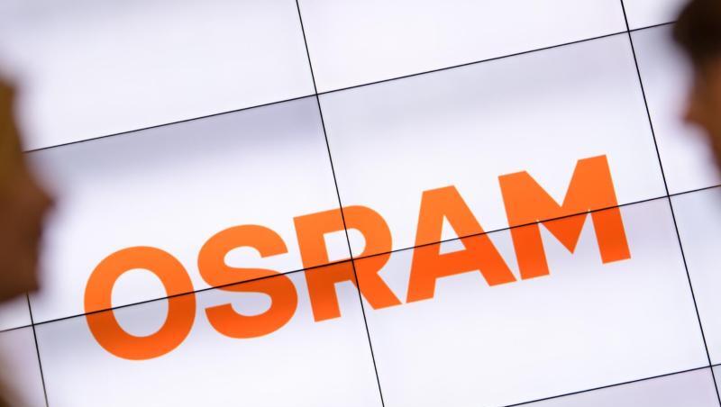 Zwei Personen unterhalten sich vor einem Osram-Logo. Foto: Matthias Balk/dpa/Symbolbild Zwei Personen unterhalten sich vor einem Osram-Logo. Foto: Matthias Balk/dpa/Symbolbild