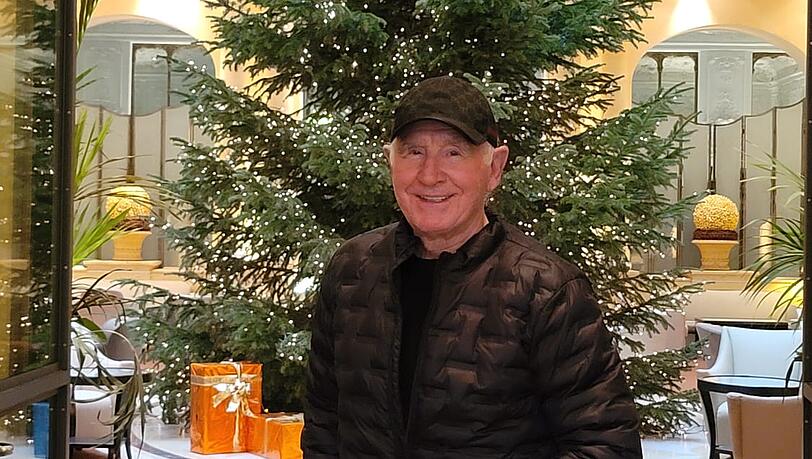 Frederic von Anhalt vor dem Christbaum im Bayerischen Hof in München. Er trägt eine Basecap, um seine Platzwunde am Kopf zu verstecken.
