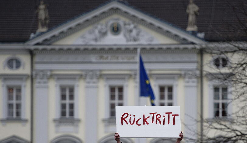 Ein Mann protestiert in Berlin vor Schloss Bellevue mit einem Schild mit der Aufschrift "Rücktritt". In der Spitze des schwarz-gelben Regierungsbuendnisses hat man den Rücktritt von Bundespraesident Christian Wulff bereits erwartet.