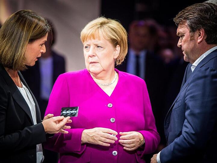 Hildegard Wortmann, Vorstand Audi, Bundeskanzlerin Angela Merkel (CDU) und Audi-Chef Bram Schot beim Eröffnungsrundgang auf der IAA am Stand von Audi.