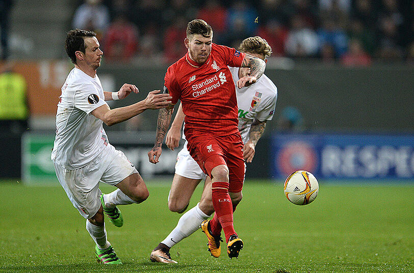 Die Augsburger Markus Feulner (links) und Alexander Esswein attackieren Alberto Moreno vom FC Liverpool. Feulner fehlt definitiv im Rückspiel - der Mittelfeldakteur zog sich beim Bundesliga-Sieg in Hannover einen Jochbeinbruch zu und muss operiert werden.