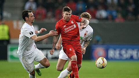 Die Augsburger Markus Feulner (links) und Alexander Esswein attackieren Alberto Moreno vom FC Liverpool. Feulner fehlt definitiv im Rückspiel - der Mittelfeldakteur zog sich beim Bundesliga-Sieg in Hannover einen Jochbeinbruch zu und muss operiert werden.