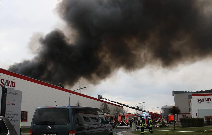 Dichter schwarzer Rauch steigt über einer Papierfabrik auf.