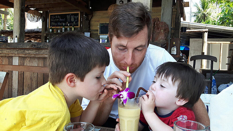 Die drei Männer Leandro, Patrick und Diego genießen einen frisch gepressten Saft auf Koh Lanta.