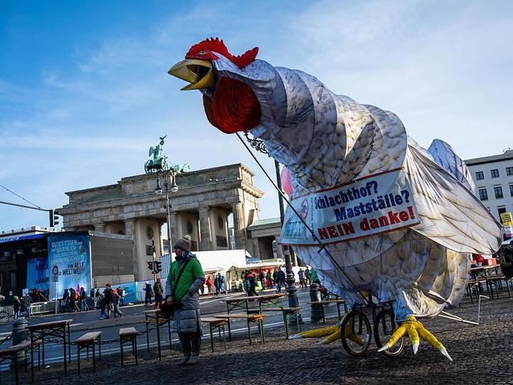 Eine überdimensionierte Hühnerfigur steht vor dem Brandenburger Tor.