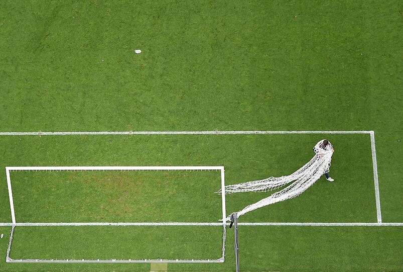 Gerard Piqué sichert sich ein Stück vom Tornetz aus dem Berliner Olympiastadion.
