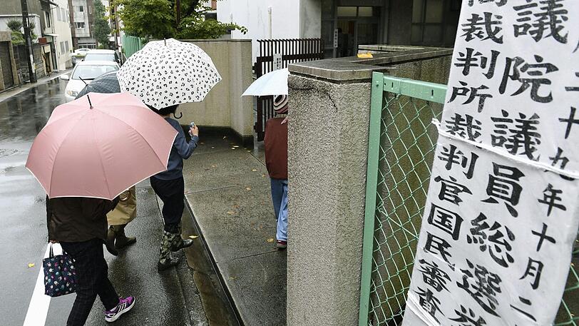 Menschen auf dem Weg in ein Wahllokal in Nagoya.
