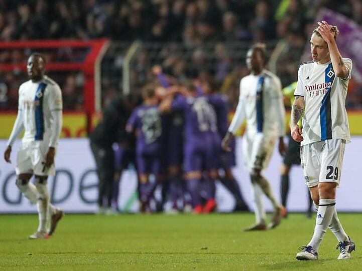 Während im Hintergrund die Osnabrücker Spieler feiern lassen die Hamburger die Köpfe hängen.
