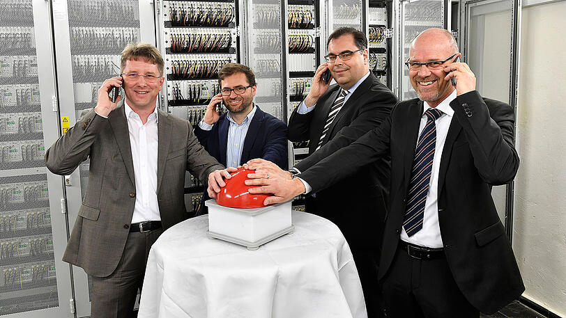 Karsten Fuchs, Leiter Netzausbau der Vodafone Region Süd, Jaime Lluch, Bereichsleiter Netzplanung Deutschland von Telefonica, Ingo Wortmann, MVG-Chef und SWM Geschäftsführer Verkehr und Michael Vogl, Leiter Mobilfunkausbau Region Süd Telekom Deutschland (v.l.), drücken symbolisch den roten Knopf in einem Technikraum im U-Bahnhof Hauptbahnhof.