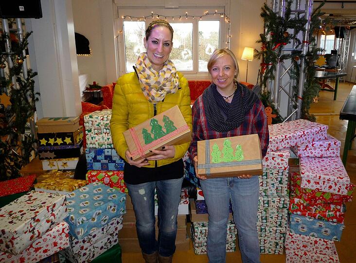 100 Weihnachtspäckchen für bedürftige Familien: Antje Breda (r.), Einrichtungsleiterin der Arche München mit Nadine Espey, Vorstandsvorsitzende des Mutter-Kind-Hilfswerks e.V. bei der Päckchenübergabe in Moosach.