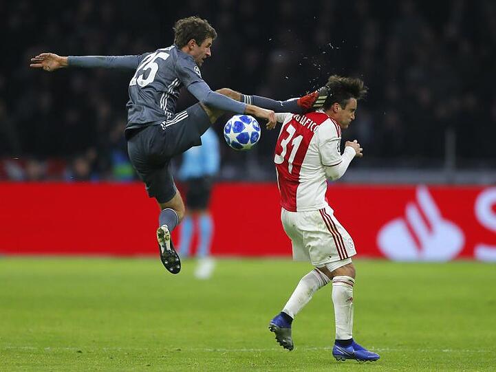 Bayerns Thomas Müller trifft Ajaxs Nicolas Tagliafico (r) mit seinem Fuß am Kopf. Foto: Peter Dejong/AP/Archiv