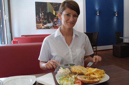 Burger, Cocktails und Kaffee: Inhaberin Olga Burdilova mit einem Cheeseburger-Menü.