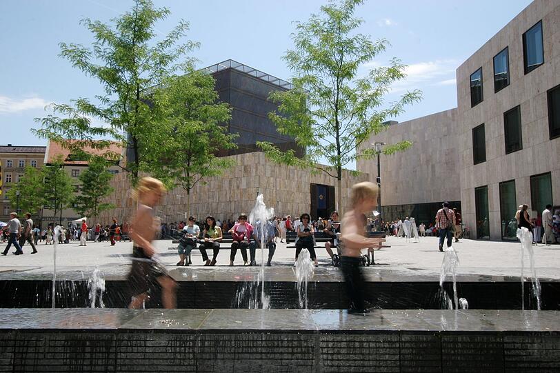 Die Gebäude am St.-Jakobs-Platz verbinden viele Zwecke. Der Platz war erst karg. Da helfen Bäume und Brunnen.