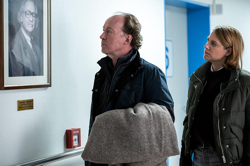 Im Krankenhaus st&ouml;&szlig;t Kommissar Stiller (Ulrich Noethen, links) auf ein Foto von Gustav Sorrow. Seine Kollegin Kira Engelmann (Bettina Burchard) erkl&auml;rt ihm, dass Sorrow viel f&uuml;r den Ort getan und auch f&uuml;r die Klinik gro&szlig;z&uuml;gig gespendet hat.