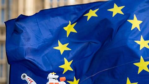 Eine EU-Flagge und ein Schiff "SS Disaster" werden bei einem Protest vor Westminster hoch gehalten. Foto: Dominic Lipinski/PA Wire/dpa