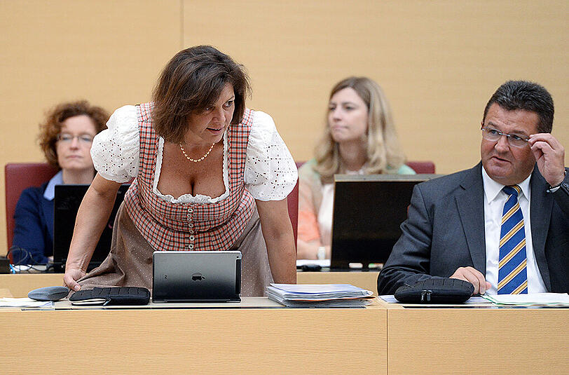 Die bayerische Wirtschaftsministerin Ilse Aigner (CSU) kommt im Dirndl zur Sitzung ins Plenum des Bayerischen Landtags in München und setzt sich neben Wirtschaftsstaatssekretär Franz Josef Pschierer (CSU).