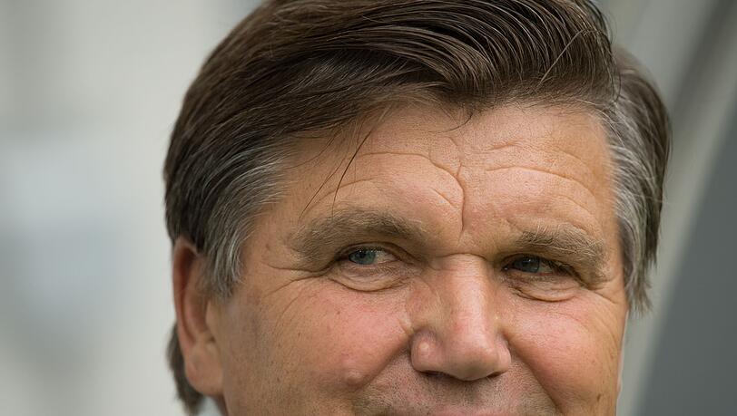 Der ehemalige Fußballtrainer Hans Meyer lächelt im Stadion.