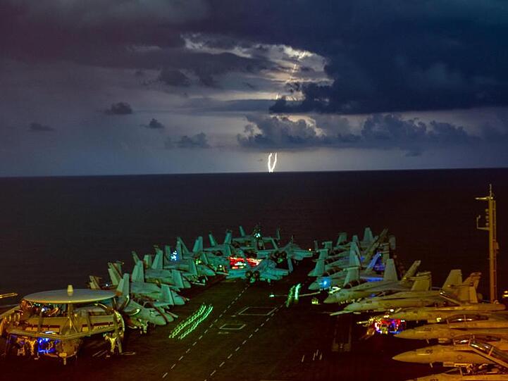 Eskaliert der Streit zwischen den USA und China? Militärjets stehen auf dem Flugdeck des Flugzeugträgers USS Nimitz im Südchinesischen Meer während eines Gewitters.