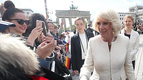 Die britische Herzogin Camilla (vorne) spricht mit Zuschauern vor dem Brandenburger Tor. Foto: Wolfgang Kumm