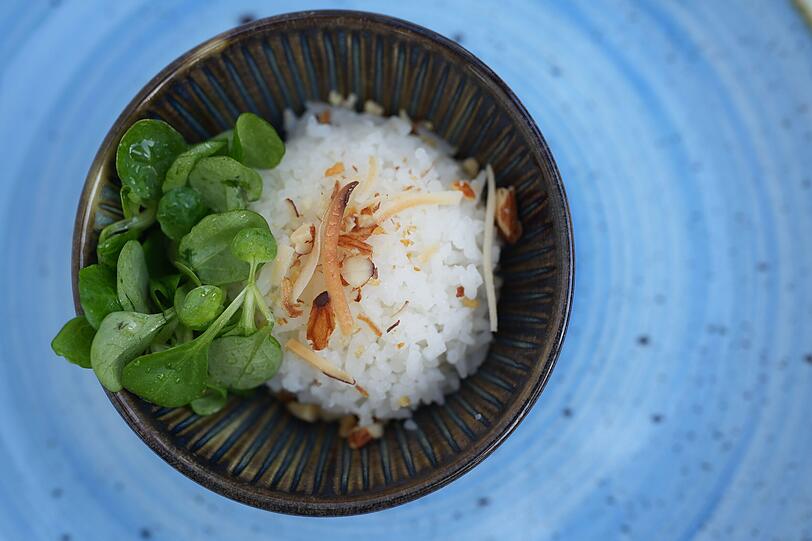 Dritter Gang: Sticky Rice – Kokosreis, salzige Mandeln, Knoblauch, Feldsalat. Dritter Gang: Sticky Rice – Kokosreis, salzige Mandeln, Knoblauch, Feldsalat.