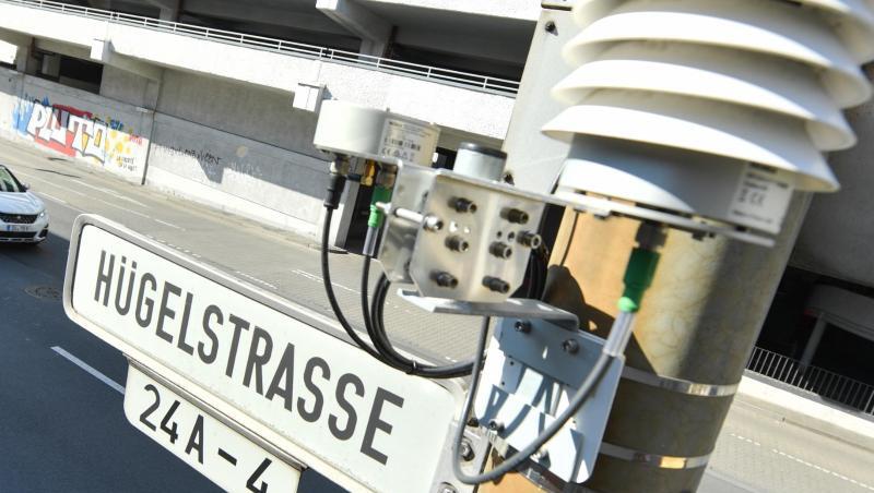 Autos fahren auf der Darmstädter Hügelstraße an einer Luftmessstation vorbei. Autos fahren auf der Darmstädter Hügelstraße an einer Luftmessstation vorbei.