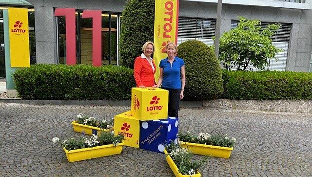 Verena Ober, Leiterin der Stabsstelle Unternehmenskommunikation der Staatlichen Lotterie- und Spielbankverwaltung und Frau Antje Singer (Unternehmenskommunikation SLSV) bei der Übergabe der Blumenkästen an die Gewinner.