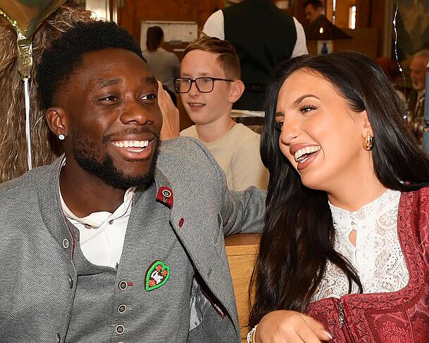 Alphonso Davies trägt einen herzigen Chef-Anstecker. Freundin Sheyenne amüsiert's. Alphonso Davies trägt einen herzigen Chef-Anstecker. Freundin Sheyenne amüsiert's.
