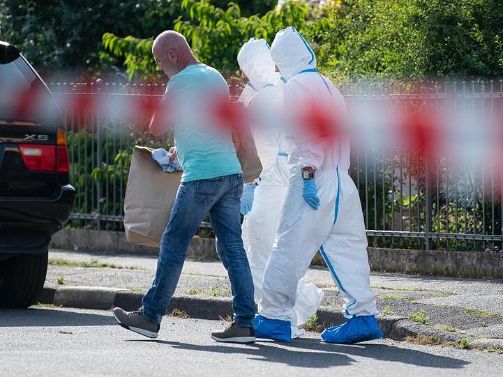 Mitarbeiter der Spurensicherung tragen Beweismaterial aus einem Einfamilienhaus in Kahl am Main. Foto: Silas Stein