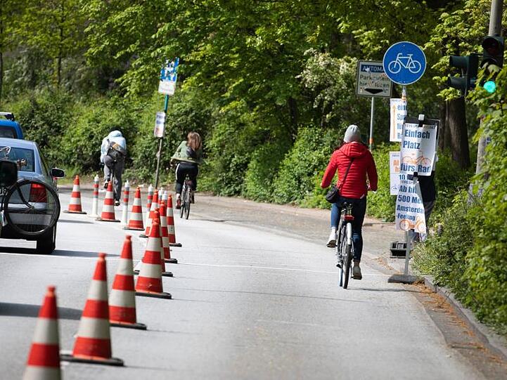 Radfahrer nutzen eine vorübergehend abgesperrte Straßenspur als Radweg. Foto: Christian Charisius/dpa/Symbolbild